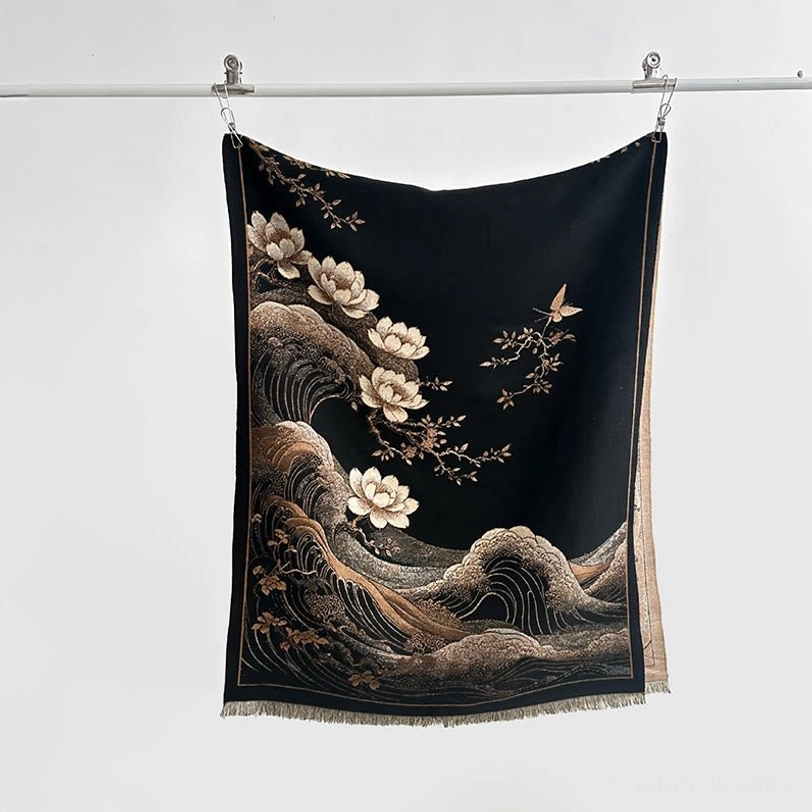 Black tassel shawl hanging display showing detailed lotus and wave print patterns with fringed edges