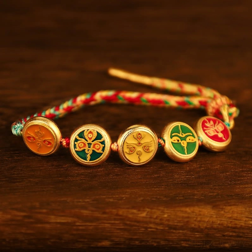 Tibetan woven luck bracelet laid flat on dark wooden surface showing complete charm sequence and colorful braided rope with loose ends