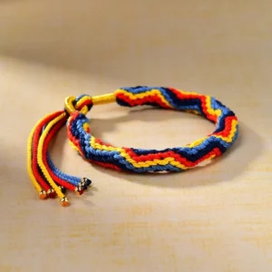 Multicolor woven Tibetan luck bracelet showing striped twisted weave pattern with adjustable tassel closure and gold bead charms