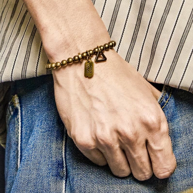 Tibetan copper luck bracelet worn on wrist with casual street style outfit