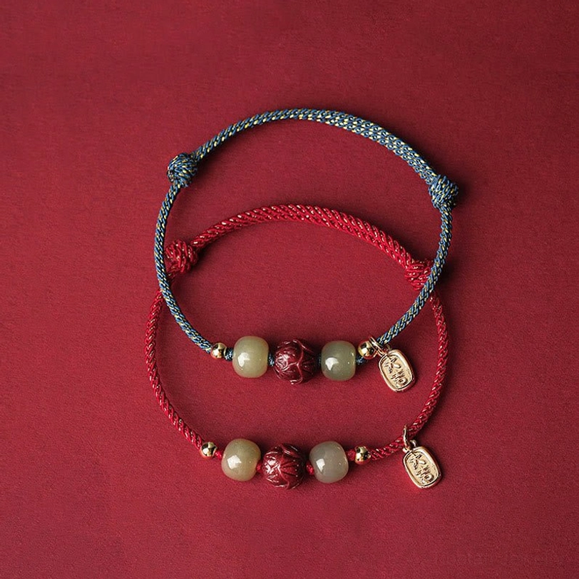 Stacked Tibetan lucky bracelets in red and blue-gray rope with natural jade beads