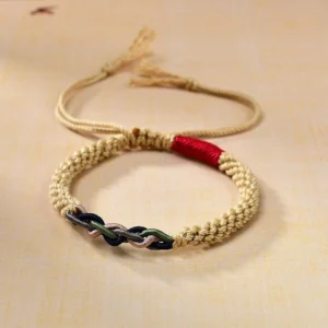 Tibetan hand-braided cotton rope lucky bracelet with golden weave and red protection knot, overhead view showing adjustable tasseled cords