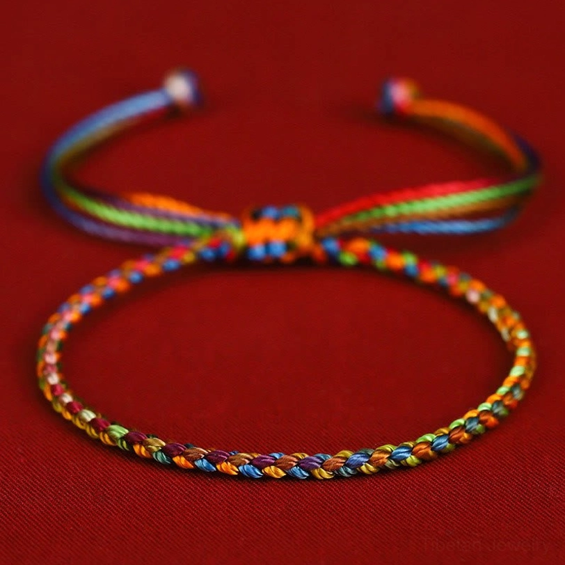 Tibetan multicolored lucky wish bracelet flat lay with adjustable knot closure on red velvet background