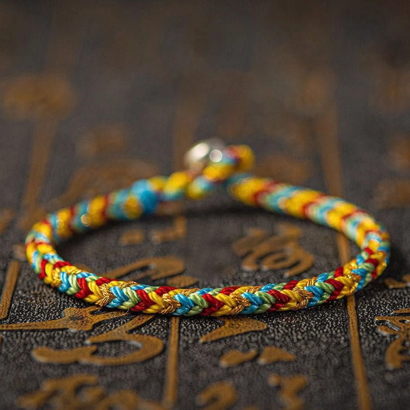 Single Tibetan lucky bracelet with silver ball clasp close-up showing craftsmanship