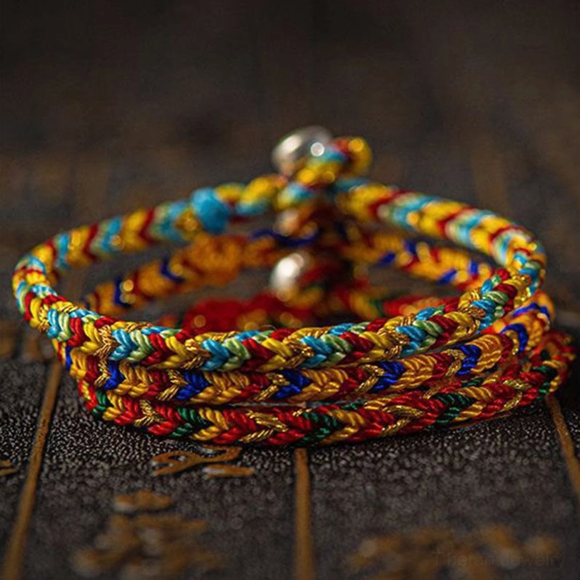 Stacked Tibetan lucky bracelets overhead view showing twisted weave texture detail