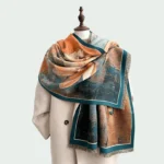 Woman wearing Tibetan magnolia butterfly scarf with orange and teal oil painting print, fringed hem detail
