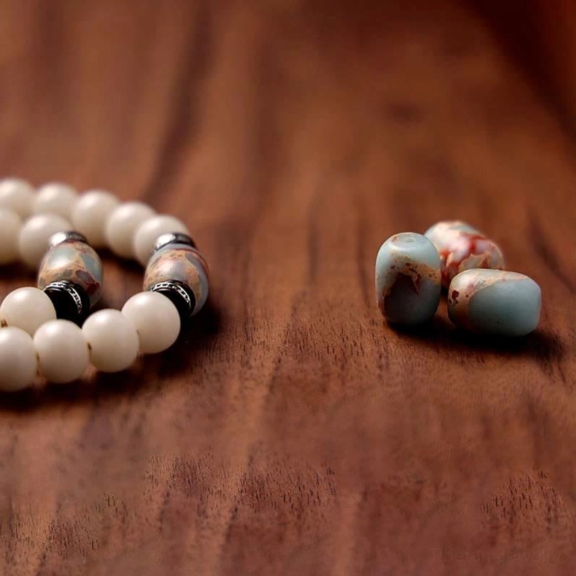 Tibetan mala beads with striped agate and natural stone beads loose arrangement on wooden desktop