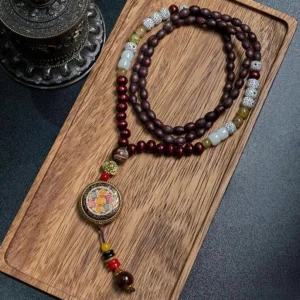 Handmade Tibetan Buddhist mala necklace with wooden beads and enamel Buddha charm from above