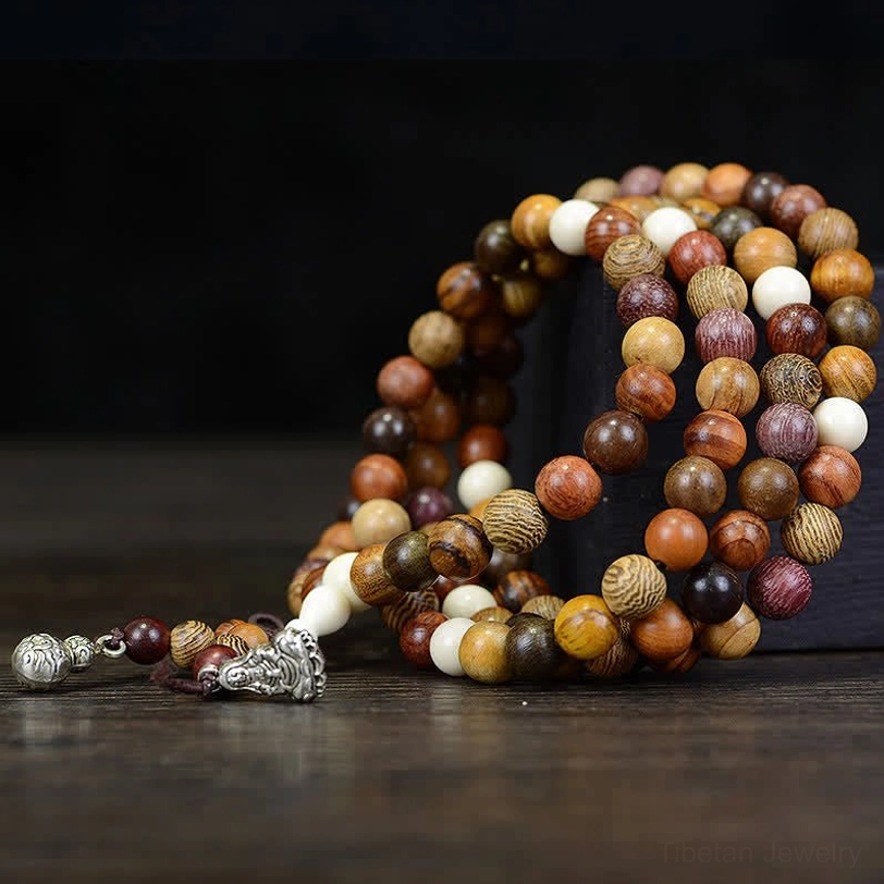 108 bead Tibetan mala necklace angled close-up with white accent beads and silver decorative charms