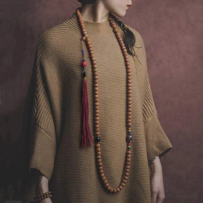Tibetan mala bead strand side view showing bodhi seeds, metal spacers, and large decorative stone beads