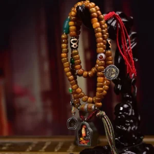 Hanging Tibetan prayer beads mala necklace displaying camel bone beads, Dzi accents, shrine pendant, and multicolor tassel