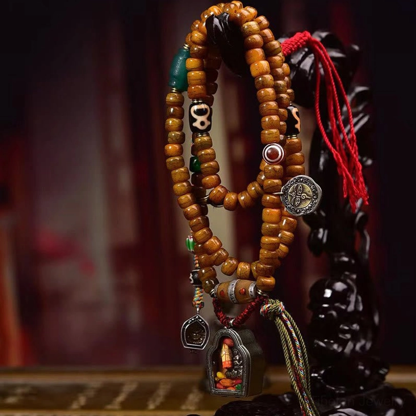 Hanging Tibetan prayer beads mala necklace displaying camel bone beads, Dzi accents, shrine pendant, and multicolor tassel
