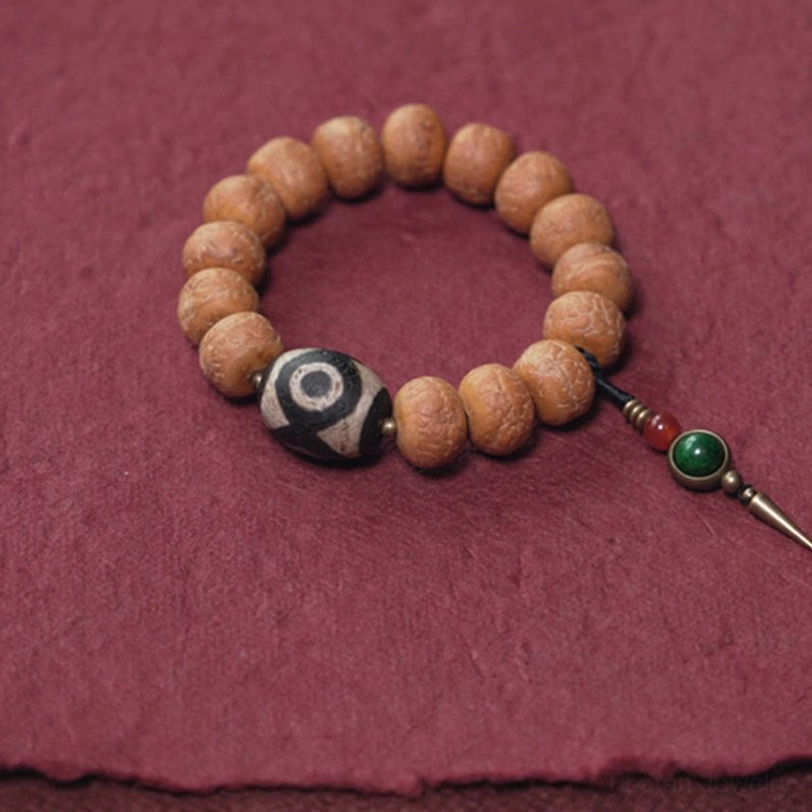 Tibetan bodhi seed dzi mala bracelet flat lay with natural textured bodily beads and pendant placed on right side