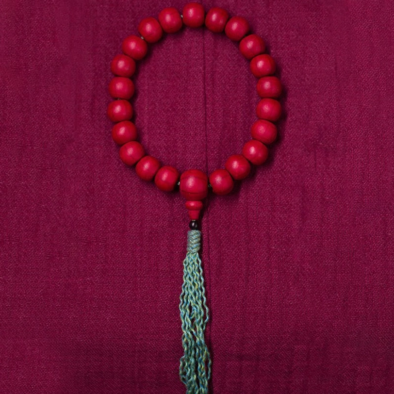 Circular tibetan prayer bead mala flat lay overhead view natural wood beads matching tassel