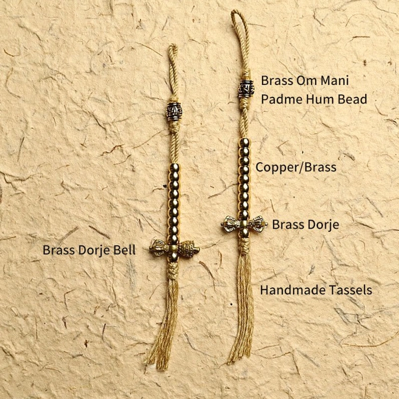 Handmade mala bracelet components and accessories including brass charms and tassels laid flat