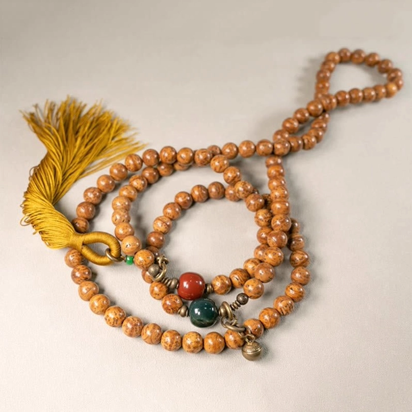 Multi-strand Tibetan bodhi seed mala flat lay showing full design with metal pendants and tassel
