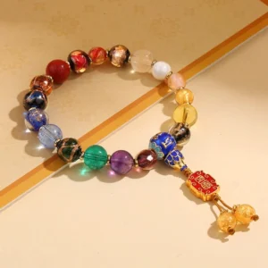 Tibetan 18-bead mala bracelet with multicolor incense ash liuli glass beads and Om Mani Padme Hum charm, flat lay on wooden background