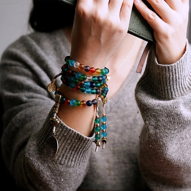 Multiple stacked mala bead bracelets with multicolored frosted glass beads on wrist, close-up hand perspective daily wear