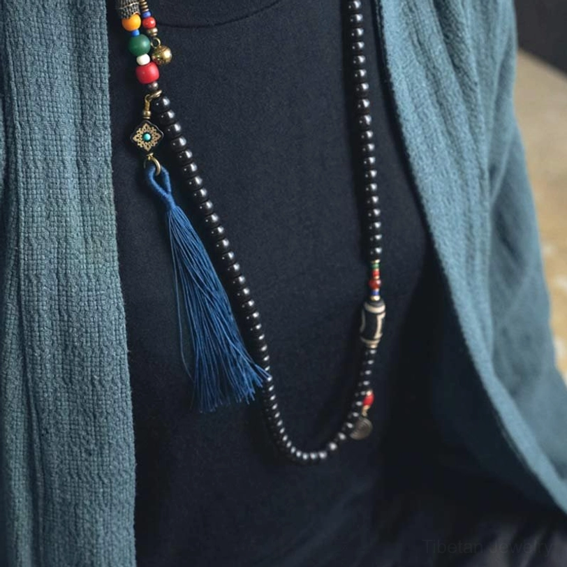 Tibetan mala prayer necklace with 108 beads featuring ebony wood, dzi bead, colorful accents and blue tassel detail