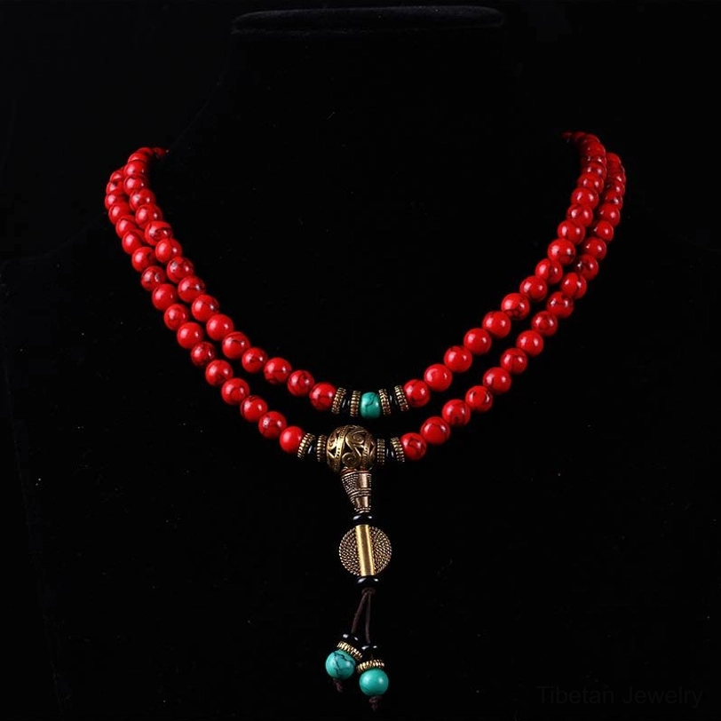 Full front display of Tibetan mala red bead necklace with bronze pendant and turquoise dangle charms