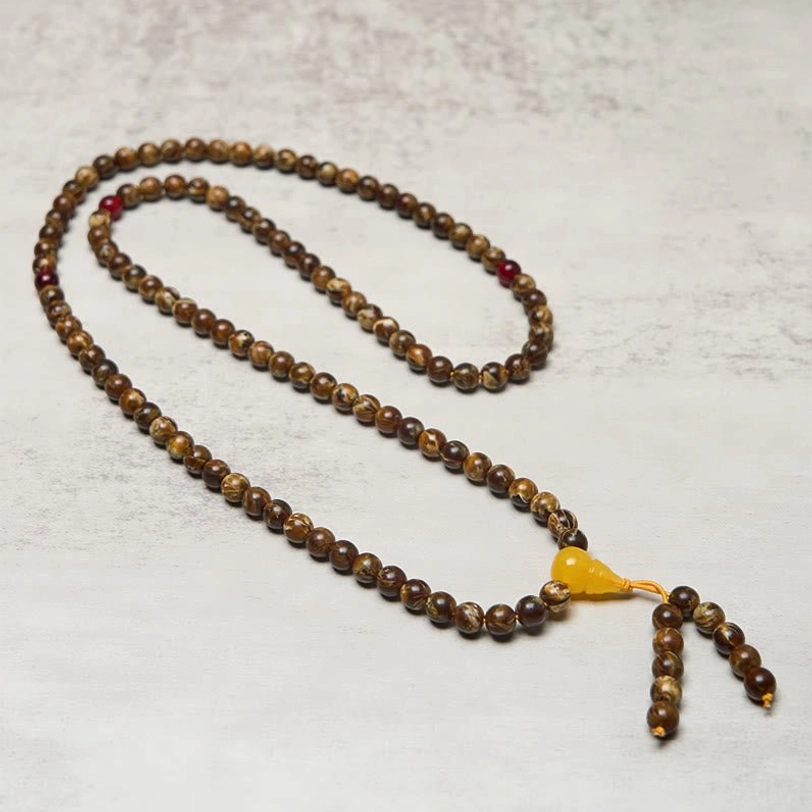 Full length stretched tibetan prayer mala necklace showing all 108 beads with red accent beads and gourd charm