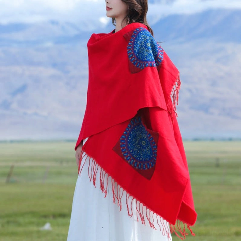 Red draped mandala poncho with blue geometric patterns and fringe trim, back side view