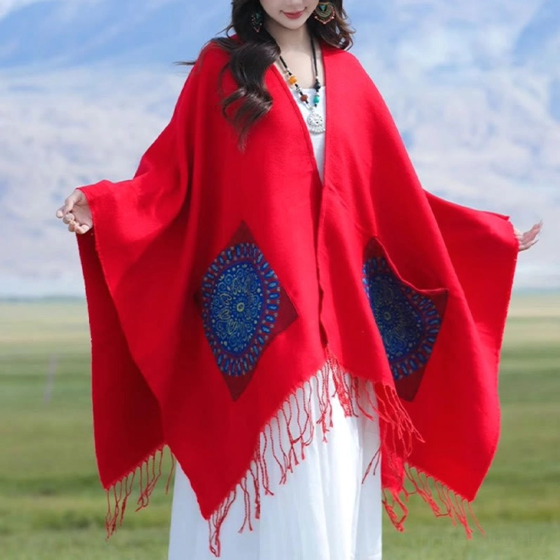 Red oversized mandala shawl with batwing sleeves and blue patterns, front wide view outdoors