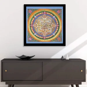 Hand-painted Kalachakra mandala thangka in black picture frame displayed above dark sideboard in modern home living room
