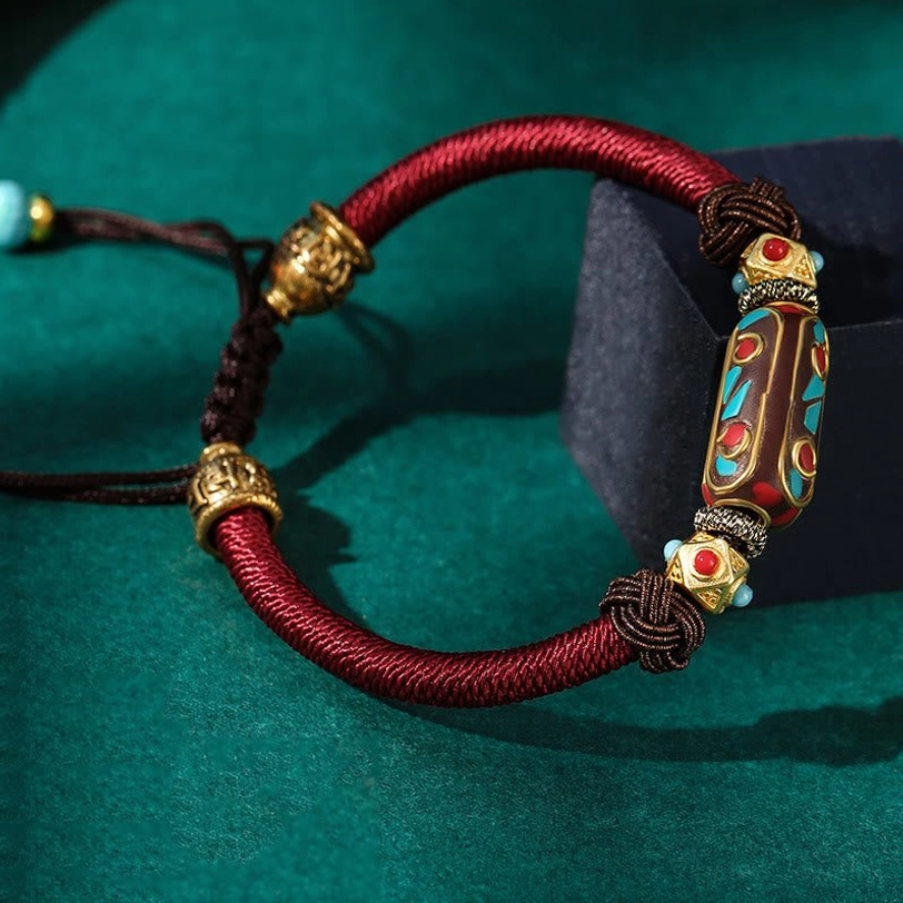 Single Tibetan Om Mani Padme Hum braided bracelet with adjustable pull cord and full set of decorative metal beads on display