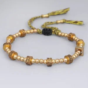 Tibetan Six True Words mantra bracelet flat lay showing brass beads with engraved characters and decorative black bead