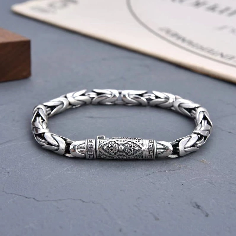 Full circle Tibetan Buddhist copper bracelet front flat view displaying closed braided chain and ornate engraved central clasp