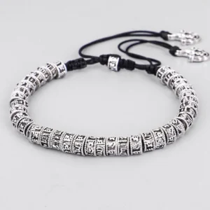 Handmade Tibetan Om Mani Padme Hum mantra bracelet with silver engraved beads and black adjustable cord, overhead flat lay on white background