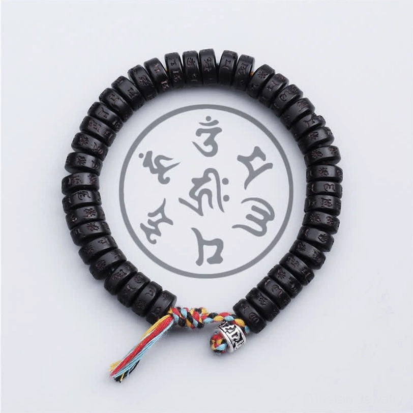 Tibetan mantra bracelet overhead full circle view displaying engraved Om Mani Padme Hum on all beads, colorful tassel closure on white background