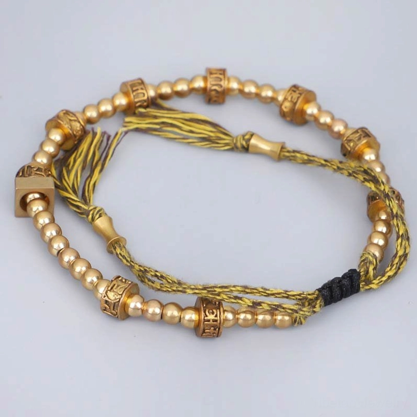 Adjustable Tibetan compassion bracelet side view showing tassel endings and rope construction