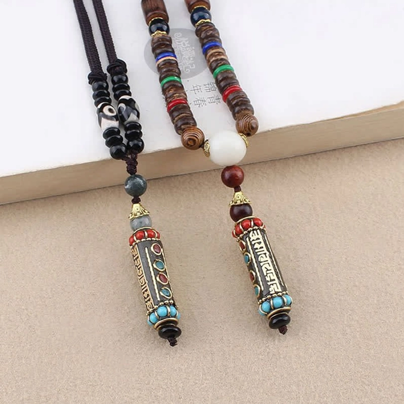 Two Tibetan Om Mani Padme Hum necklaces with white round accent beads, flat lay comparison