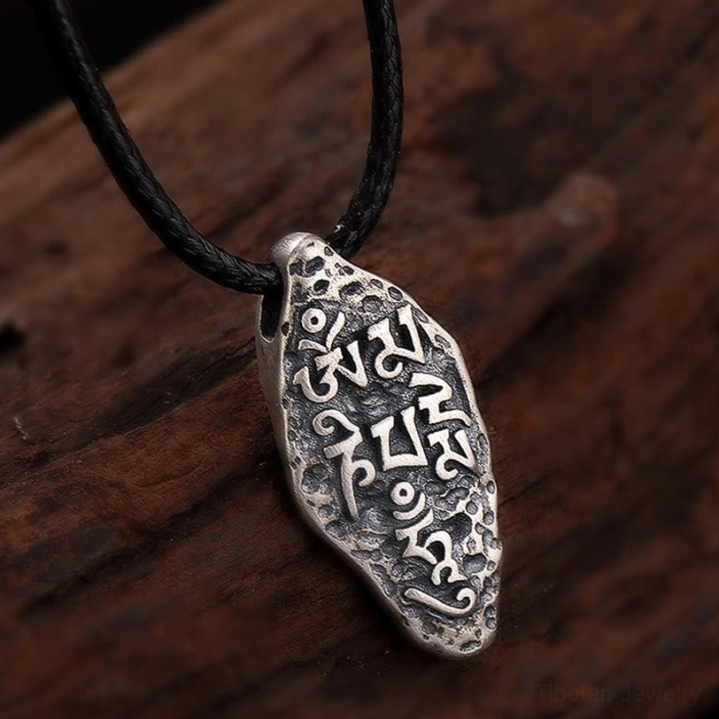 Om Mani Padme Hum mantra pendant with clear engraved Sanskrit text and dark patina details on silver