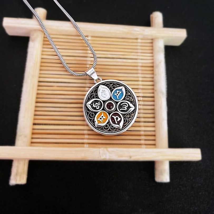 Om Mani Padme Hum pendant displayed on bamboo stand showing front snake chain and neat mantra pattern