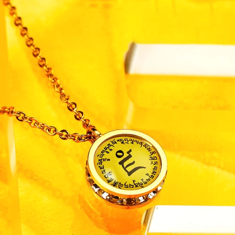 Tibetan mantra round pendant front close-up with surrounding sacred script and central mantra character in gold frame