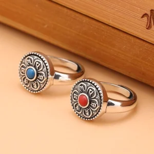 Handcrafted Tibetan mantra ring with rotating band, red and blue gemstone options, shown with wooden gift box and vintage silver finish detail