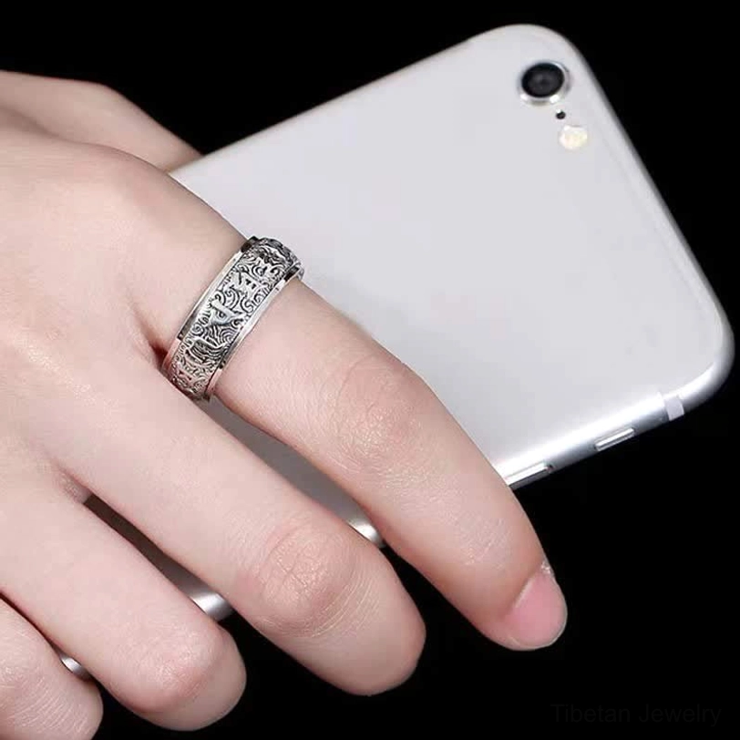 Om Mani Padme Hum rotatable ring worn on hand showing natural fit and vintage copper texture against dark background