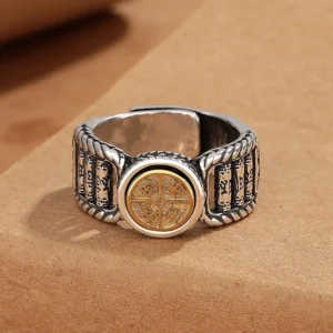 Two-tone Tibetan mantra ring with oxidized silver band and carved gold rotating central disc featuring Om Mani Padme Hum characters, front top view