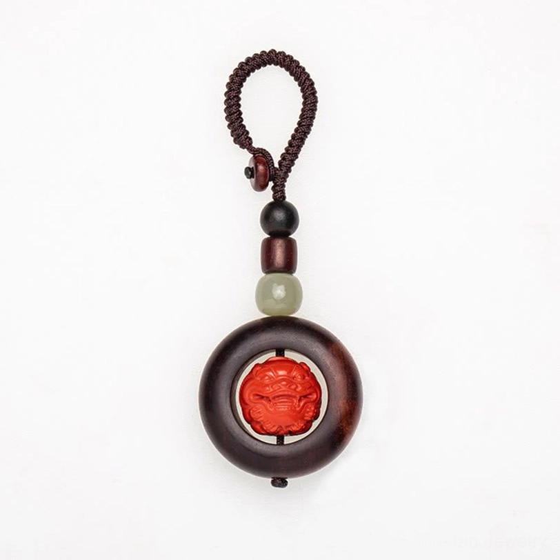 Close-up of hand-carved mantra symbols on Tibetan protection keychain cinnabar bead