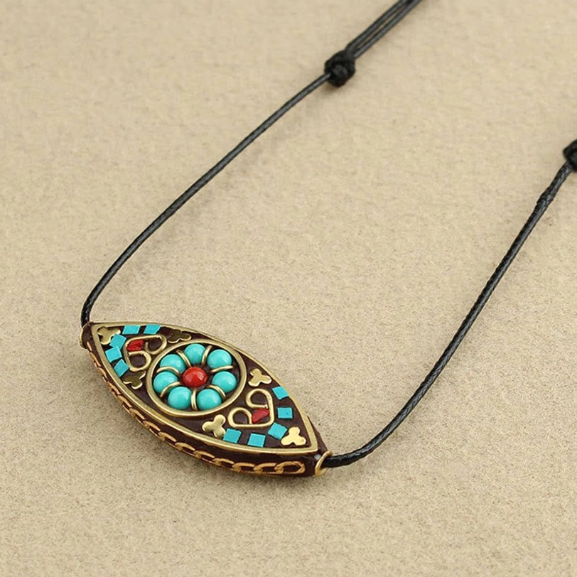 Tibetan marquise turquoise pendant with red floral design center and ethnic patterns, top view