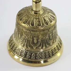 Close-up detail of Tibetan meditation bell showing intricate carved brass patterns and polished surface finish