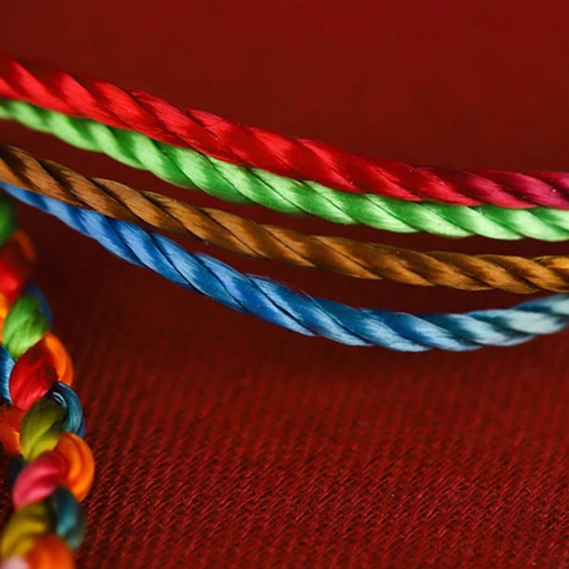 Close-up of four twisted braided color strands in Tibetan lucky bracelet with smooth silk texture