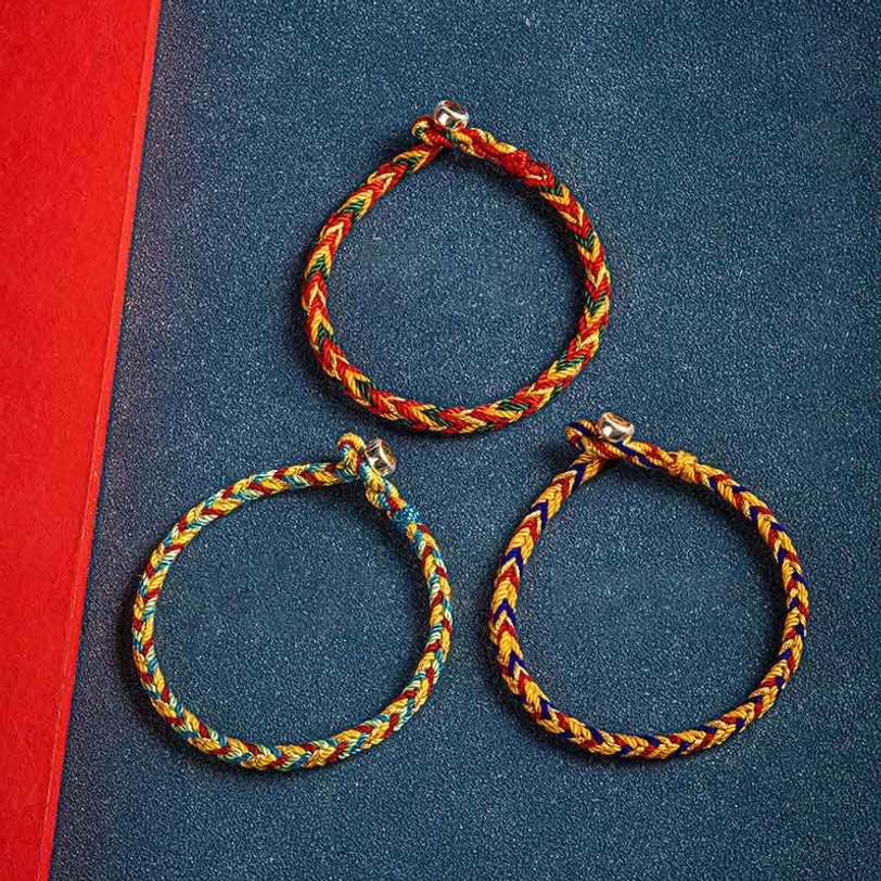 Three handmade Tibetan protection bracelets in matching multicolor styles arranged on contrasting red and blue background