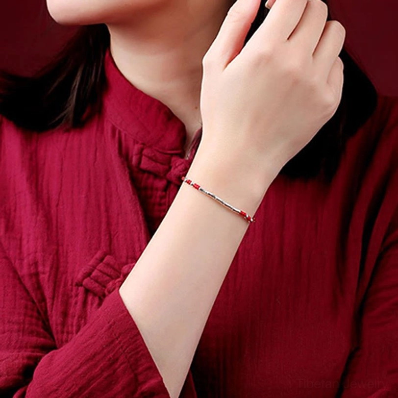 Detailed view of Tibetan multicolor braided protection bracelet with copper bamboo-shaped beads worn on wrist