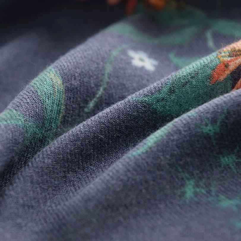 Navy blue Tibetan scarf fabric close-up showing detailed floral motifs and smooth fuzzy surface with rich botanical pattern