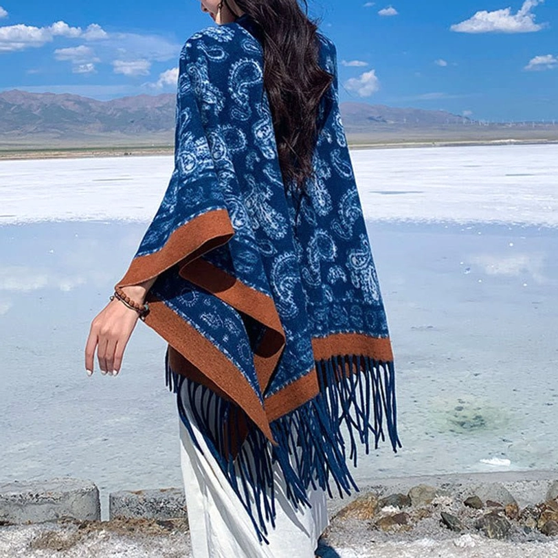 Tibetan navy paisley scarf with long fringe hem, brown edging and white geometric patterns, displayed in side back perspective at salt lake scenery
