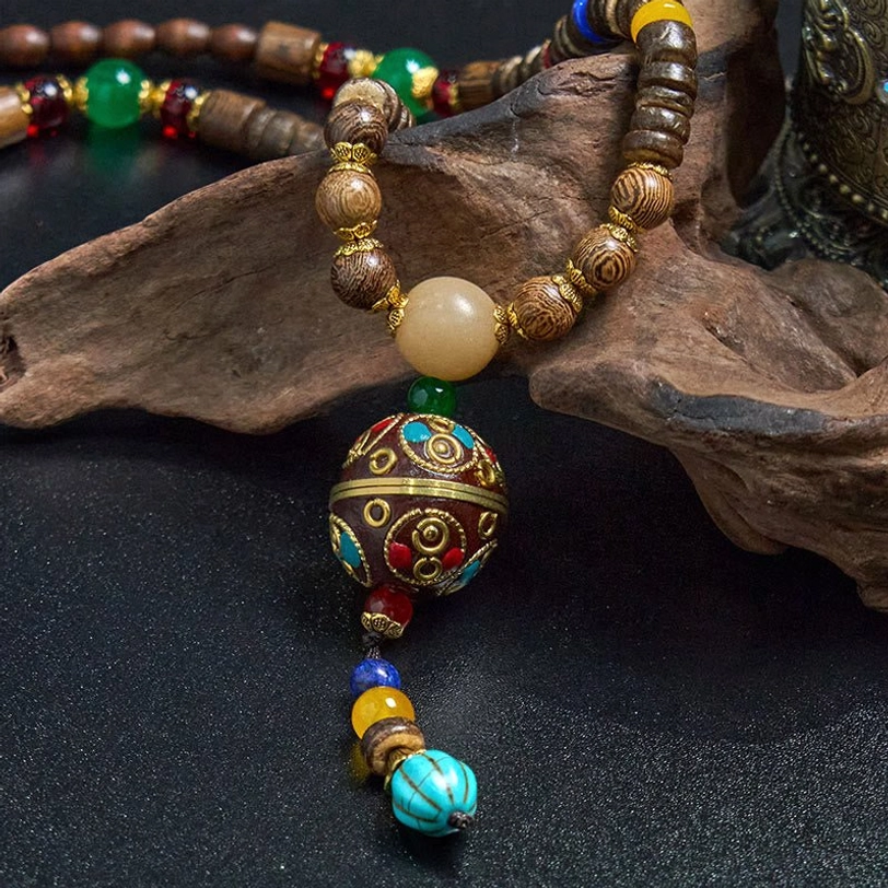 Tibetan Buddhist necklace with brown wooden beads, green blue red accent beads, and traditional tassel charm